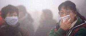 Unerträgliche Luft. Frauen auf der Straße in der Stadt Harbin.