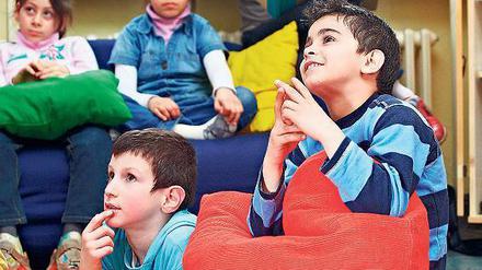 Gespannte Zuschauer. Beim „Bilderbuchkino“ werden die Zeichnungen aus Büchern an die Wand projiziert und die Kinder erzählen, was sie sehen. So verbessert sich ihre Sprache. 