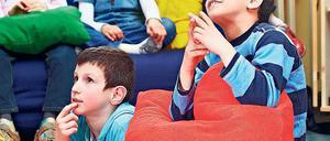 Gespannte Zuschauer. Beim „Bilderbuchkino“ werden die Zeichnungen aus Büchern an die Wand projiziert und die Kinder erzählen, was sie sehen. So verbessert sich ihre Sprache. 