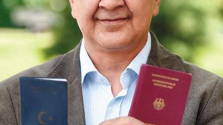 Mann zeigt seinen türkischen und seinen deutschen Pass