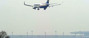 Eine Maschine der Fluggesellschaft Ryanair landet auf dem Flughafen in Schönefeld. Im Hintergrund ist der noch nicht eröffnete BER zu sehen.