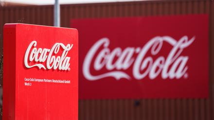 Das Coca-Cola Logo ist an der Fassade einer Produktionshalle angebracht. 