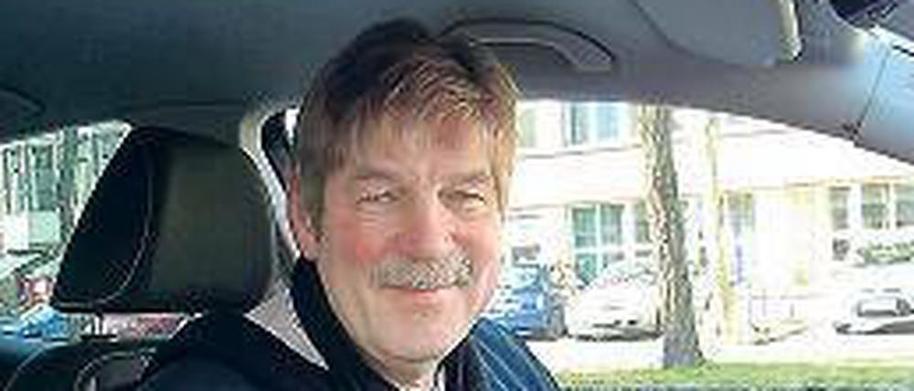 Georg Grasshoff in seinem Fahrschulauto, in der Hand ein spezieller Drehknopf.