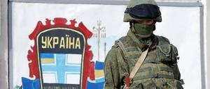 Streng bewacht. Vor der Militärbasis der ukrainischen Streitkräfte in Perewalnoje auf der Krim steht ein Bewaffneter, der offenbar zur russischen Armee gehört. Seit Tagen werden die ukrainischen Stützpunkte auf der Krim von Russen blockiert.