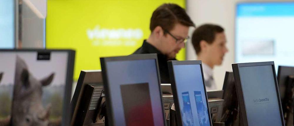 Besucher der Cebit an einem Messestand.