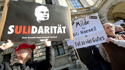 Fans halten zum Prozessauftakt vor dem Landgericht München Transparente mit der Aufschrift "Sulidarität" und "Milde für Uli Hoeneß" in die Höhe.