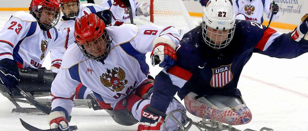 Kampf auf dem Eis. Der Amerikaner Pauls ringt mit dem Russen Shikhow um den Puck.