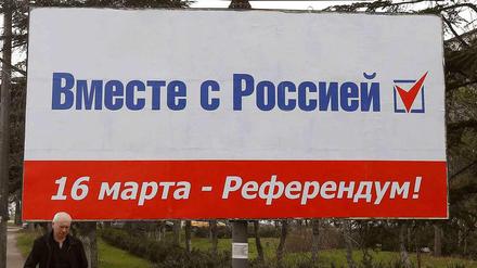 Vor dem Referendum auf der Krim am Sonntag: Ein Mann läuft unter einem Wahlplakat mit der Aufschrift: "Zusammen mit Russland. 16 März - Referendum!"