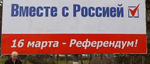Vor dem Referendum auf der Krim am Sonntag: Ein Mann läuft unter einem Wahlplakat mit der Aufschrift: "Zusammen mit Russland. 16 März - Referendum!"