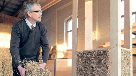 Wer baut denn da mit Stroh und Lehm? Christian Silberhorn führt den Umgang mit Strohballen für ökologisches Bauen vor.