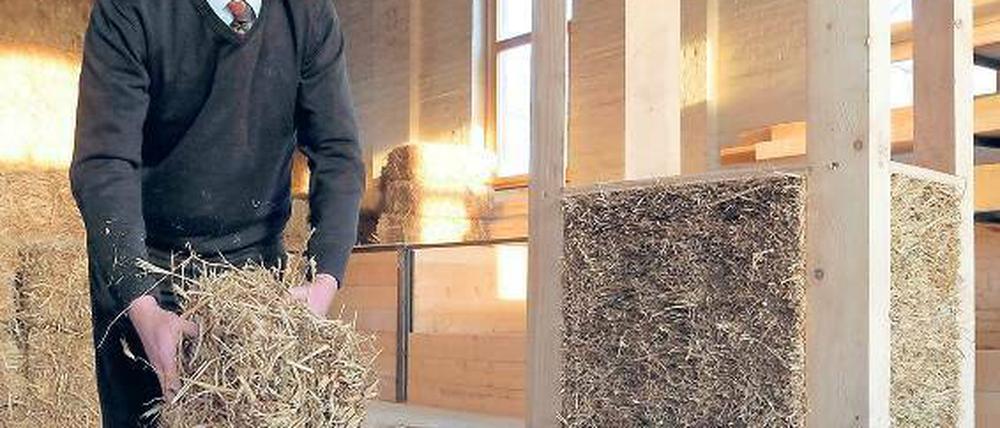 Wer baut denn da mit Stroh und Lehm? Christian Silberhorn führt den Umgang mit Strohballen für ökologisches Bauen vor.