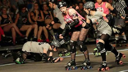 Ab und zu geht es auch mal zu Boden. Die "Berlin Bombshells" (grau) im Wettkampf gegen die Londoner "Brawl Saints" (pink) in einem Roller Derby. 