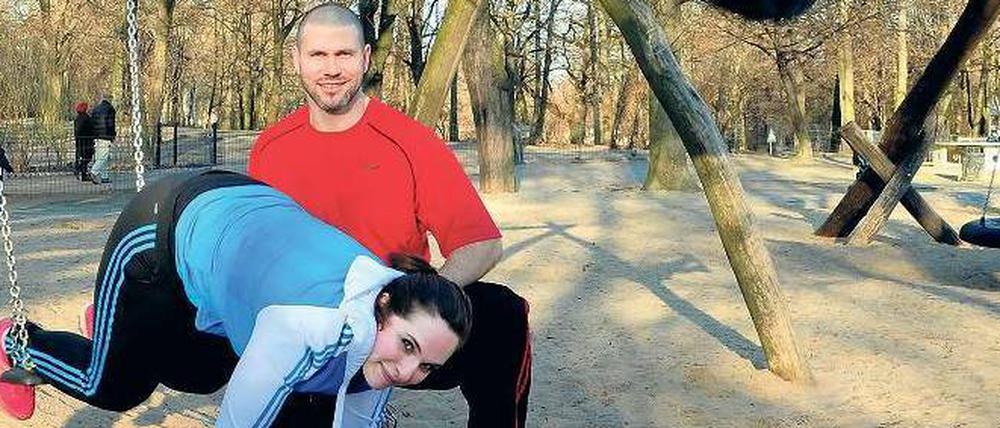 Spielend trainiert. Während Sohn Alexis schaukelt, macht seine Mama Teresa Malikiossis am selben Gerät Rumpf-Übungen. Personal Trainer Matthias John gibt am Anfang noch etwas Hilfestellung. Danach muss sie allein ran: im Stütz die Füße auf der Schaukel ranziehen und wieder wegdrücken. Da zwackt es im Bauch. 