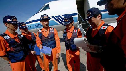 Die japanische Küstenwache steht vor einem Flugzeug