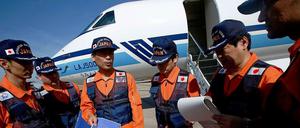 Die japanische Küstenwache steht vor einem Flugzeug