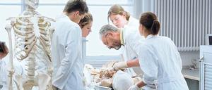 Medizinstudierende und ihr Professor stehen in der Pathologie an einem Präparationstisch.