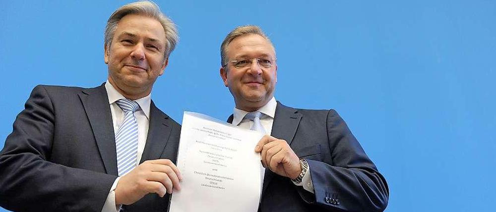 Berlins Regierender Bürgermeister Klaus Wowereit (SPD) und Innensenator Frank Henkel (CDU) posieren mit Koalitionsvertrag.