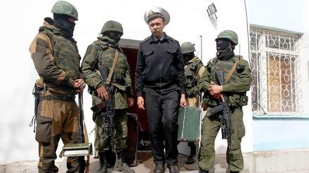 Ein ukrainischer Marinesoldat verlässt umringt von pro-russischen Milizen den Stützpunkt in Sewastopol.