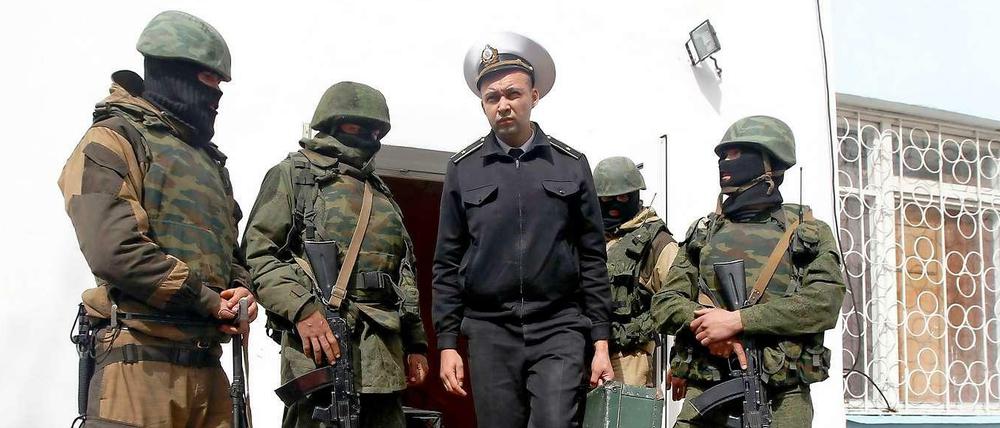 Ein ukrainischer Marinesoldat verlässt umringt von pro-russischen Milizen den Stützpunkt in Sewastopol.