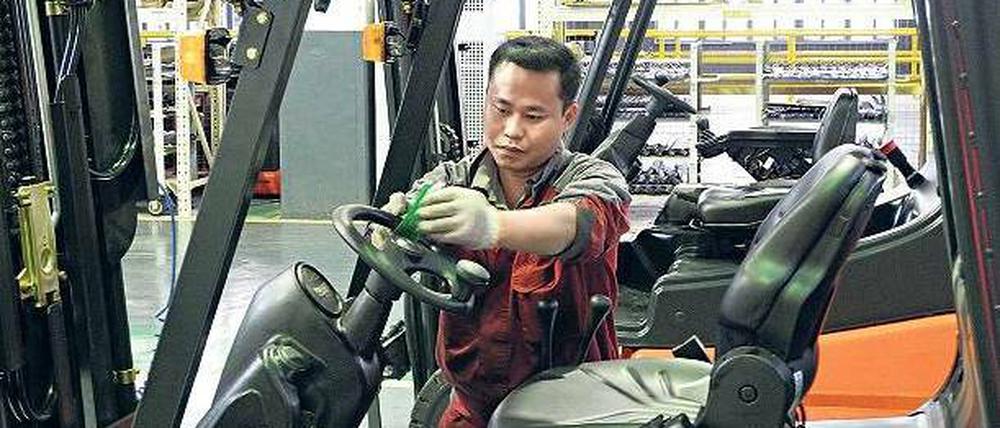 Gekauft. Ein Mitarbeiter von Kion baut in Xiamen einen Gabelstapler von Linde zusammen. 