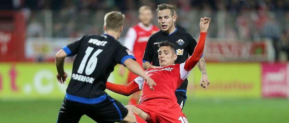 Paderborner Zange. Unions Damir Kreilach (rotes Trikot) behauptet den Ball.