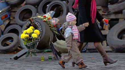 Vorbei an Barrikaden: Eine Mutter mit ihrem Kind in der Nähe des Unabhängigkeitsplatzes in Kiew. Dort spricht heute auch Außenminister Steinmeier mit der ukrainischen Führung. 