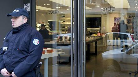 Ein Polizei steht vor einer Luxusboutique, die zuvor von zwei bewaffneten Tätern ausgeraubt worden war.