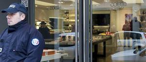 Ein Polizei steht vor einer Luxusboutique, die zuvor von zwei bewaffneten Tätern ausgeraubt worden war.