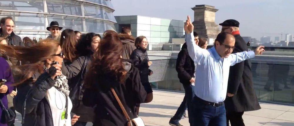 Er ist "happy": Özcan Mutlu und seine Besucher auf dem Dach des Bundestags.