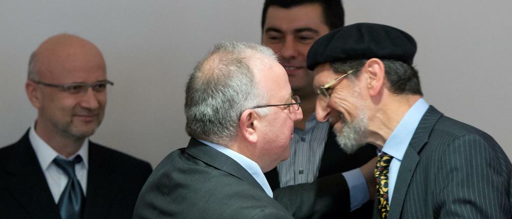 Der Bundesvorsitzende der Türkischen Gemeinde in Deutschland, Kenan Kolat (2.vl), begrüßt am Montag in Berlin vor einer Beratung mit Teilnehmern der Islamverbände im Bundesinnenministerium den Bundesvorsitzenden der Organisation Ahmadiyya Muslim Jamaat, Abdullah Uwe Wagishauser (r).