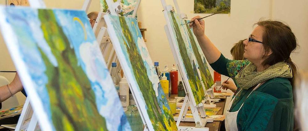 Gestaffelte Staffeleien. Thema im „Malsalon“ in Prenzlauer Berg waren dieses Mal van Goghs „Zypressen“. Eine Reproduktion der Vorlage hängt hinten an der Wand.