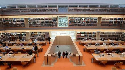 Menschen sitzen arbeitend an Tischen im Lesesaal der Berliner Staatsbibliothek Unter den Linden.