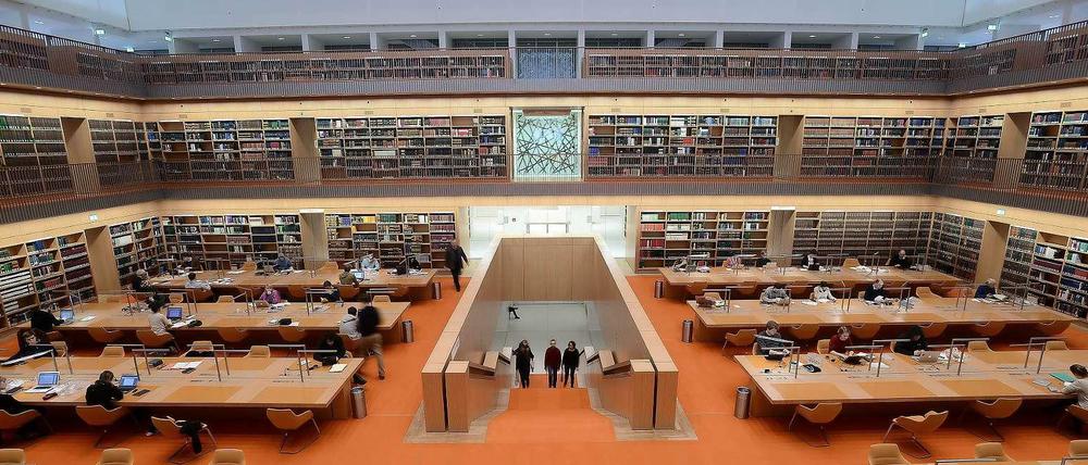 Menschen sitzen arbeitend an Tischen im Lesesaal der Berliner Staatsbibliothek Unter den Linden.