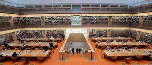 Menschen sitzen arbeitend an Tischen im Lesesaal der Berliner Staatsbibliothek Unter den Linden.