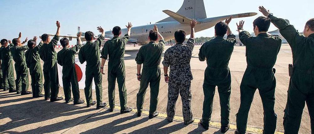 Japanische Rettungskräfte verabschieden ihre Kameraden, die bei der Suche nach dem verschollenen Flug MH 370 helfen.