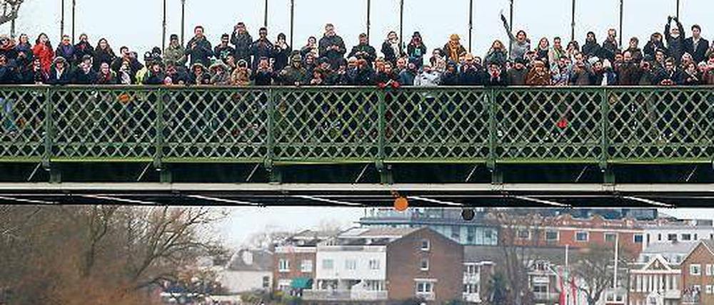 Umstrittenes Spektakel. Tausende Zuschauer bestaunen alljährlich das Themserennen zwischen Oxford (links) und Cambridge, wie hier auf der Hammersmith-Brücke. Unter den Studenten selbst ist das Boat Race dagegen nicht unbedingt beliebt. Foto: Reuters