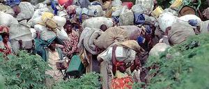 Ein Land zieht aus. Innerhalb der ersten 24 Stunden nach dem Beginn des Völkermords waren 250 000 Tutsi aus Ruanda ins Nachbarland Tansania geflüchtet. Drei Monate später zogen mehr als eine Million Hutu ins damalige Zaire - auf der Flucht vor Vergeltung. Das Foto zeigt den Flüchtlingstreck aus Zaire zurück nach Ruanda im Jahr 1996. 
