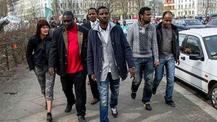 Bashir Zakharia (in Janker und rotem Pulli) wirbt unter den Flüchtlingen dafür, das Angebot des Senats anzunehmen. Am Dienstag schauten sie sich das neue Heim in der Gürtelstraße an.