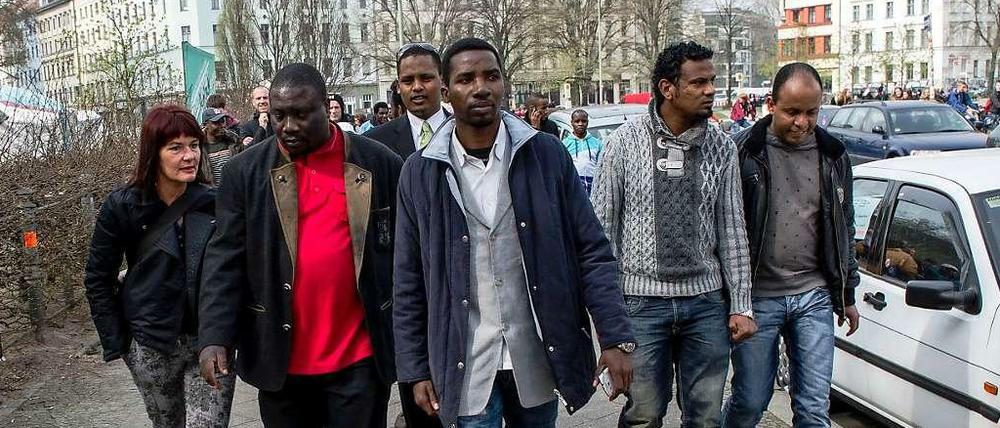 Bashir Zakharia (in Janker und rotem Pulli) wirbt unter den Flüchtlingen dafür, das Angebot des Senats anzunehmen. Am Dienstag schauten sie sich das neue Heim in der Gürtelstraße an.