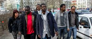 Bashir Zakharia (in Janker und rotem Pulli) wirbt unter den Flüchtlingen dafür, das Angebot des Senats anzunehmen. Am Dienstag schauten sie sich das neue Heim in der Gürtelstraße an.