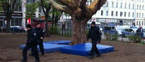 Die Polizei hat unter der Platane auf dem Oranienplatz, auf der die Frau seit Dienstag ausharrt, zur Absicherung Turnmatten ausgelegt.