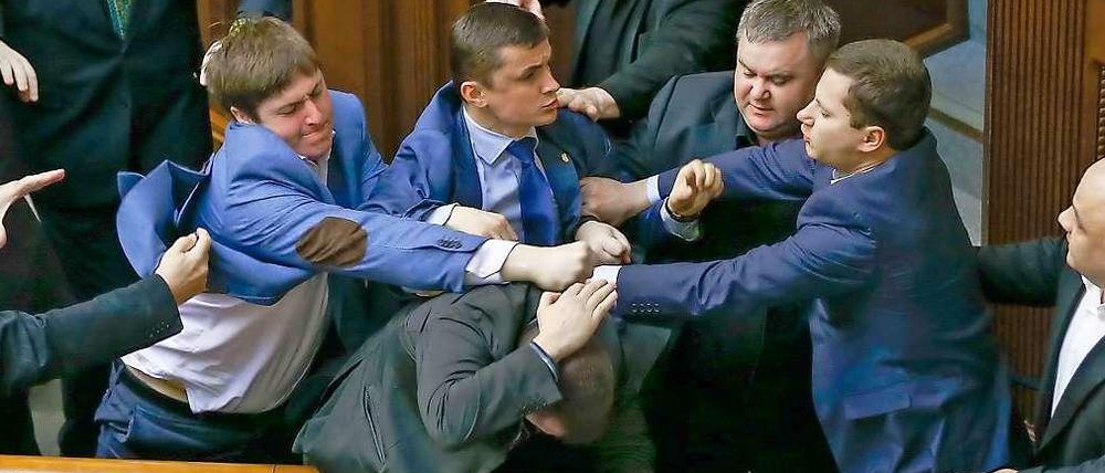 Abgeordnete der rechtspopulistischen Swoboda-Partei und Parlamentarier der Kommunisten liefern sich eine Schlägerei.