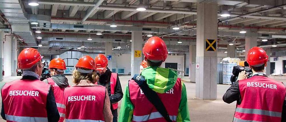 Manager, Experten und Berater sind am BER fast so schnell wieder weg wie diese Besucher, die über die Baustelle geführt werden.