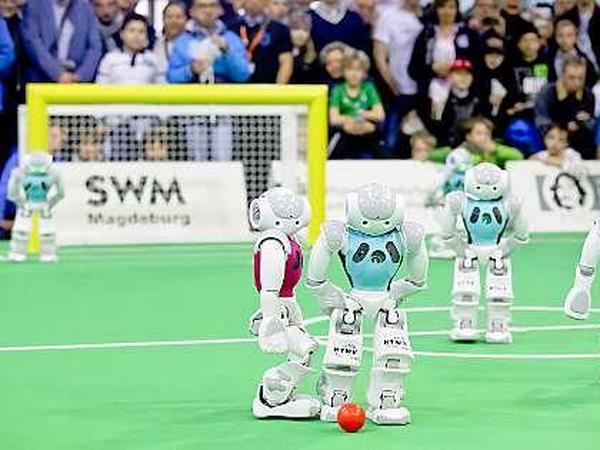 Anstoß, Pass und Tor. Bei den Robotern geht es manchmal so schnell wie auf dem echten Rasen.