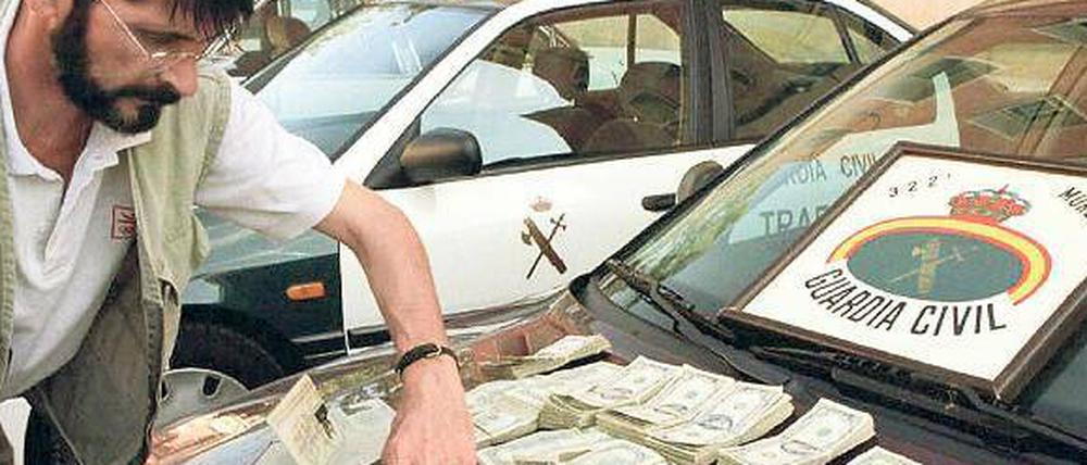 Ein spanischer Beamter prüft Banknoten und Dokumente bei einer früheren Razzia im Fall Reemtsma.