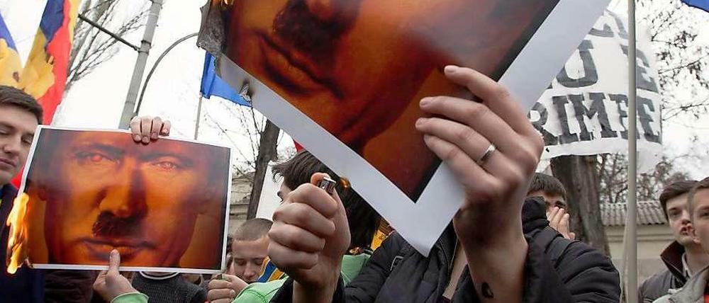 Protest gegen Moskau. Demonstranten in Moldawien setzen Anti-Putin-Plakate in Brand.