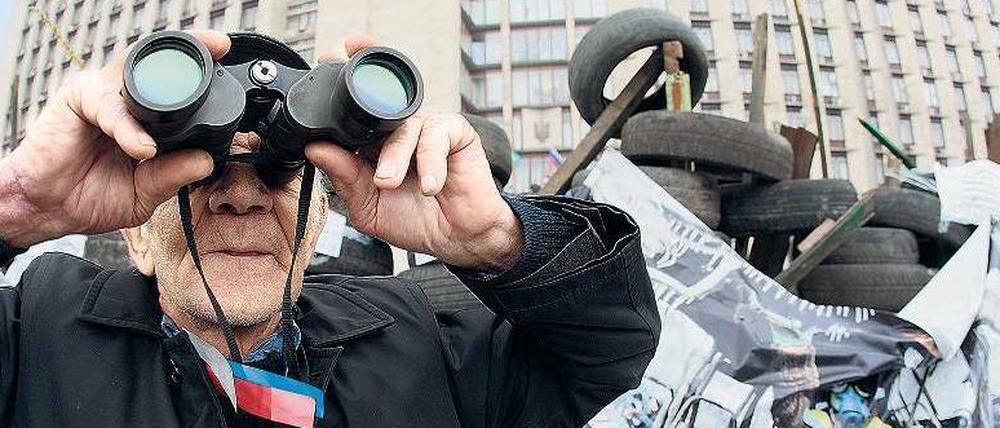 Ein pro-russischer Demonstrant bewacht Barrikaden in Donezk.