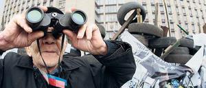 Ein pro-russischer Demonstrant bewacht Barrikaden in Donezk.