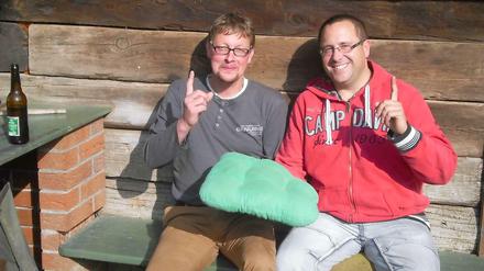 Charly und Dolf präsentieren den GBB auf einem grünen Samtkissen.