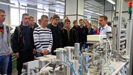 Junge Männer schauen sich eine Ausbildungswerkstatt bei Siemens an.